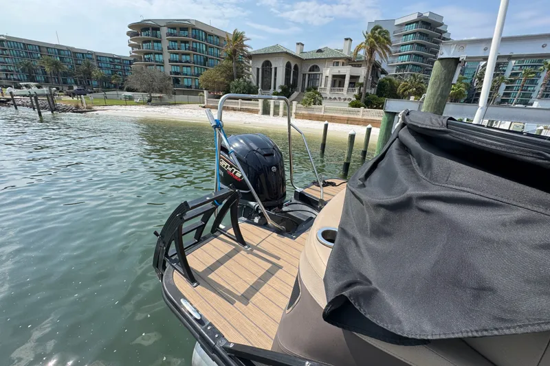 Slide: The Image of 2022 Bennington 23 LXFB pontoon boat docked near luxury waterfront homes. - 12