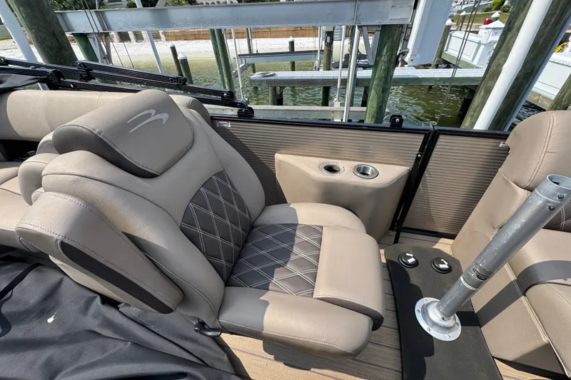 Slide: The Image of 2022 Bennington 23 LXFB boat interior with beige seating and cup holders. - 19