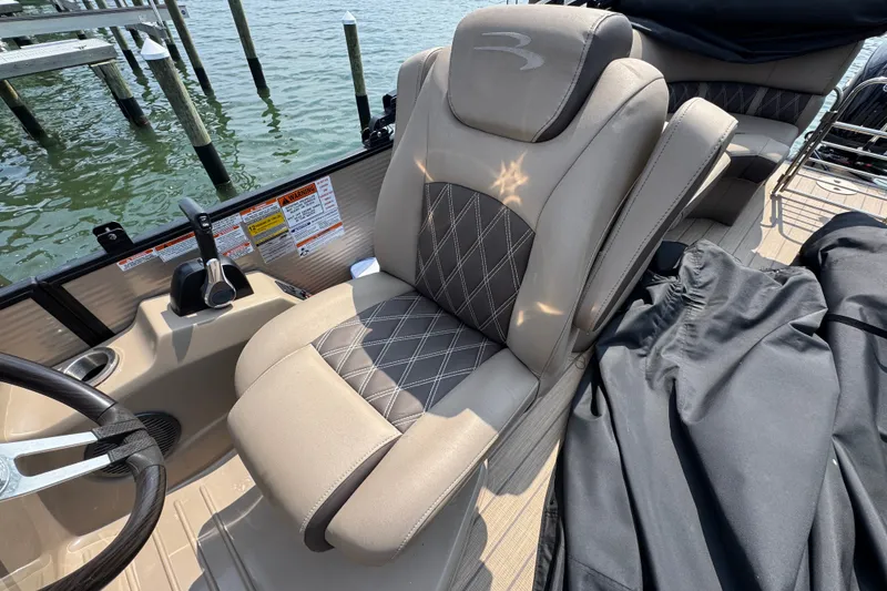 Slide: The Image of Captain's seat on 2022 Bennington 23 LXFB boat, featuring luxurious beige upholstery. - 14