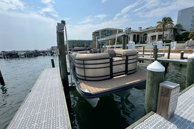 Slide: The Image of 2022 Bennington 23 LXFB pontoon boat docked at a marina with waterfront buildings. - 3