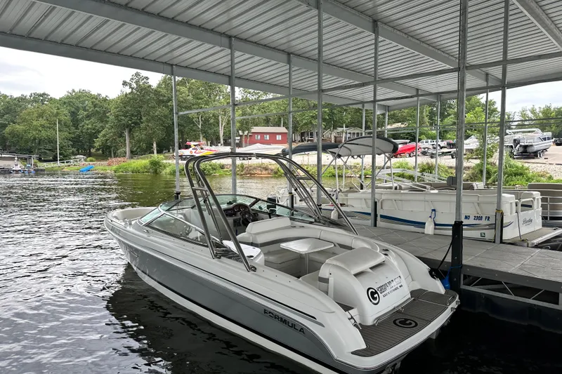 Slide: The Image of 2004 Formula 260 Bowrider docked at a marina under a covered slip. - 18