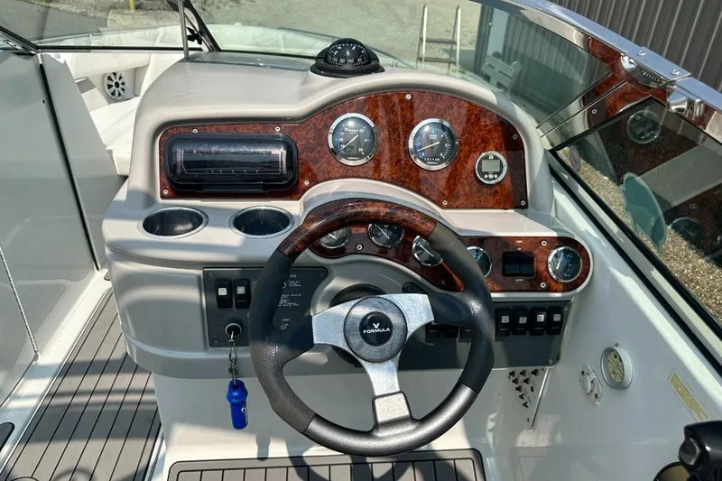 Slide: The Image of Steering console of a 2004 Formula 260 Bowrider boat with wood accents and gauges. - 12
