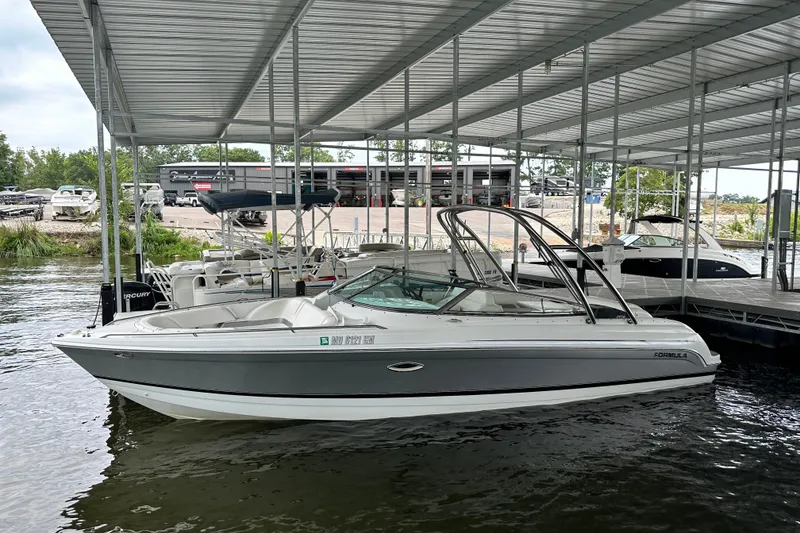 Slide: The Image of 2004 Formula 260 Bowrider docked under a covered marina. - 16