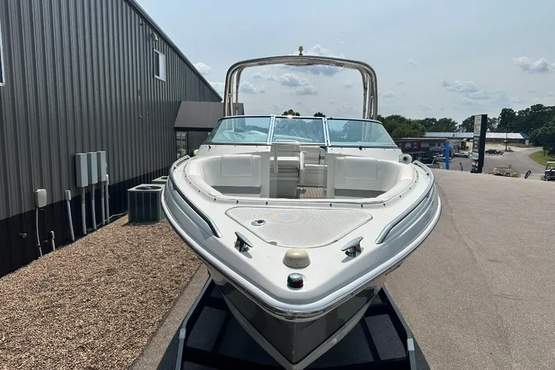 Slide: The Image of 2004 Formula 260 Bowrider boat displayed outdoors near a metal building. - 2