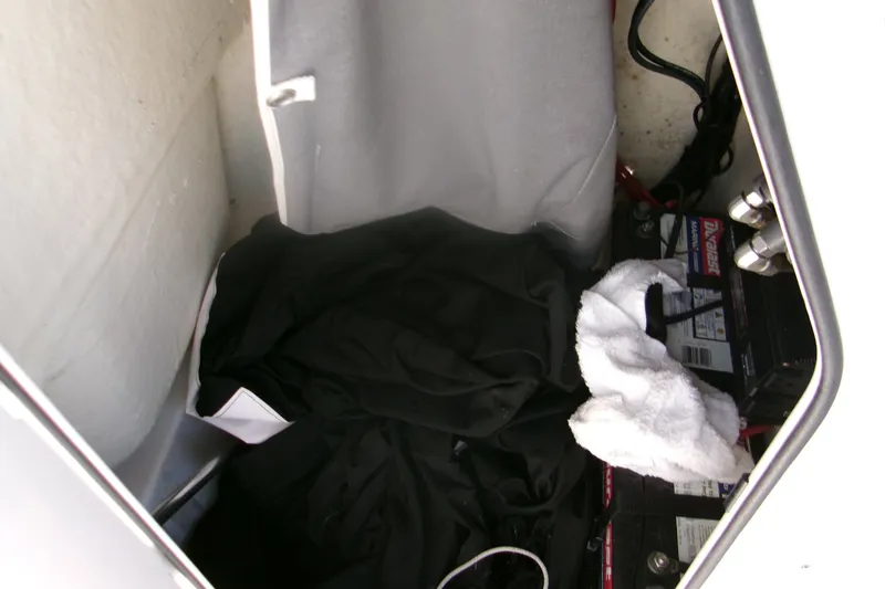 Slide: The Image of Storage compartment of 2022 Key West 189 FS boat with battery and cloth items. - 21