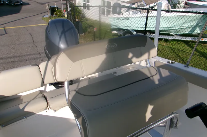 Slide: The Image of 2022 Key West 189 FS boat interior with cushioned seating and outboard motor. - 14