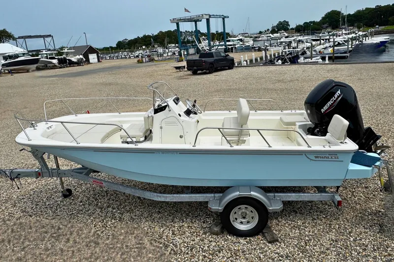 The Image of 2027 Boston Whaler 170 Montauk boat on trailer at marina, side view. - 0