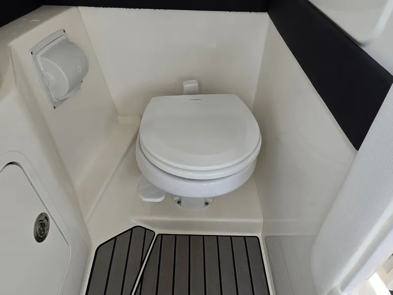 Slide: The Image of The image shows a clean, white boat toilet with gray flooring. - 21