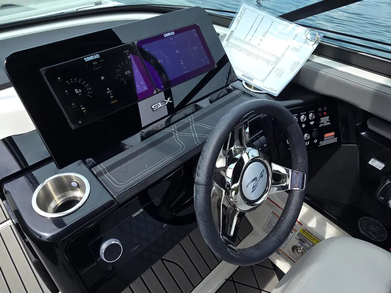 Slide: The Image of The image shows the helm of a 2025 Sea Ray SLX 260 Surf boat with modern instruments. - 13