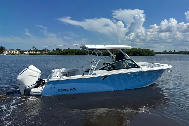 The Image of 2024 Blackfin 272 DC boat on calm water under a clear blue sky. - 0