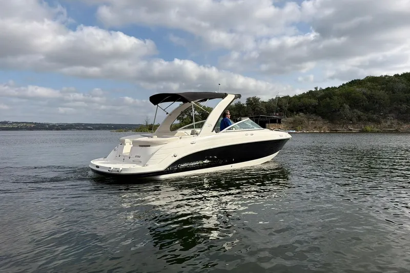 Slide: The Image of 2008 Chaparral 256 SSi boat cruising on a scenic lake under a cloudy sky. - 19