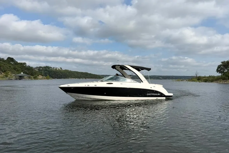 Slide: The Image of 2008 Chaparral 256 SSi boat cruising on a calm lake under a cloudy sky. - 7