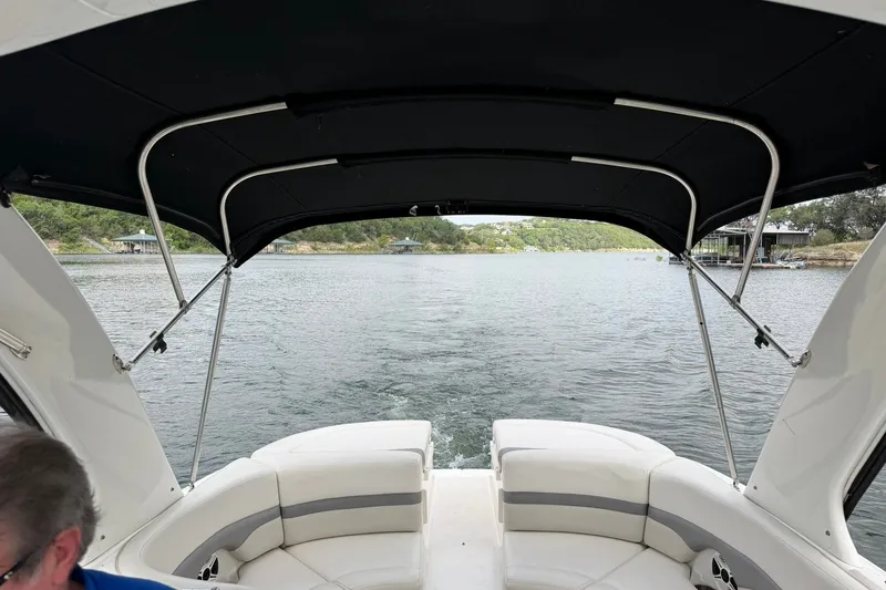 Slide: The Image of 2008 Chaparral 256 SSi boat interior with canopy, cruising on a scenic lake. - 56