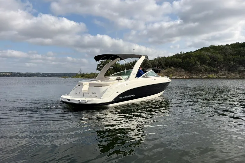 Slide: The Image of 2008 Chaparral 256 SSi boat cruising on a calm lake under a cloudy sky. - 20