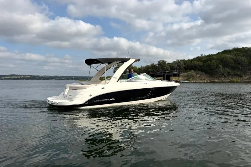 Slide: The Image of 2008 Chaparral 256 SSi boat cruising on a scenic lake under a cloudy sky. - 18