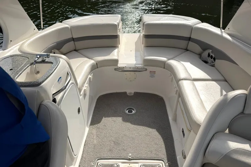 Slide: The Image of 2008 Chaparral 256 SSi boat interior with seating and sink, on calm water. - 31
