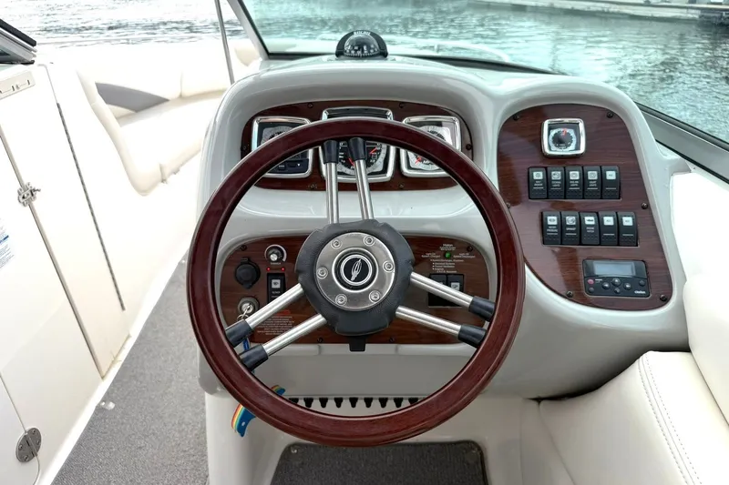 Slide: The Image of Steering wheel and dashboard of 2008 Chaparral 256 SSi boat, featuring wood accents. - 4
