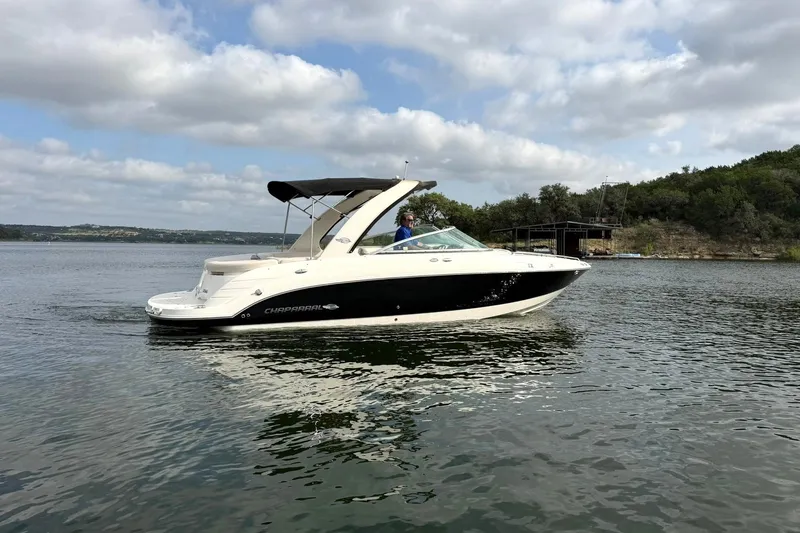 Slide: The Image of 2008 Chaparral 256 SSi boat cruising on a scenic lake under a cloudy sky. - 2