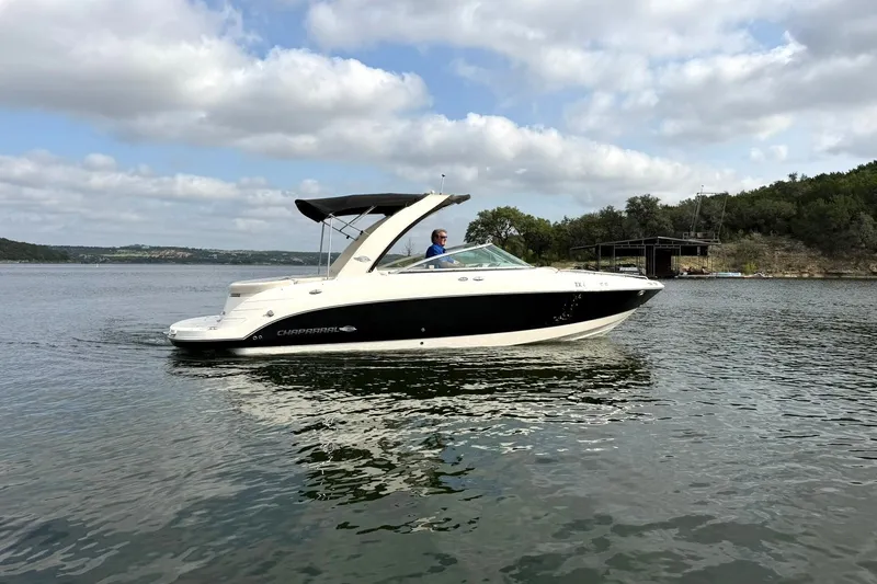 Slide: The Image of 2008 Chaparral 256 SSi boat cruising on a scenic lake under a cloudy sky. - 17