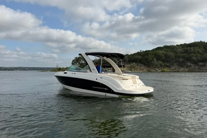 Slide: The Image of 2008 Chaparral 256 SSi boat cruising on a scenic lake under a cloudy sky. - 24