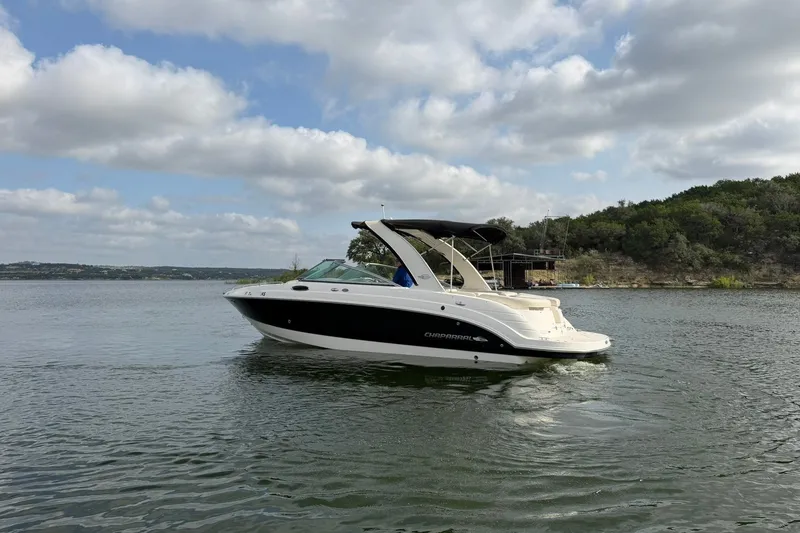 Slide: The Image of 2008 Chaparral 256 SSi boat cruising on a scenic lake under a cloudy sky. - 25