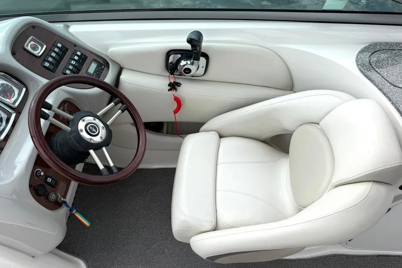 Slide: The Image of 2008 Chaparral 256 SSi boat cockpit with steering wheel and white captain's chair. - 49