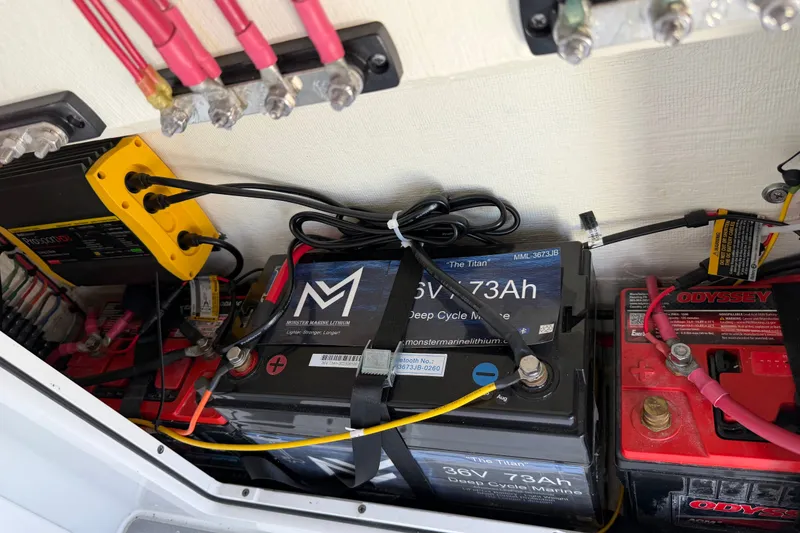 Slide: The Image of Battery compartment of 2024 Costa Custom Boats 264HC, featuring Monster Marine Lithium and Odyssey batteries. - 21