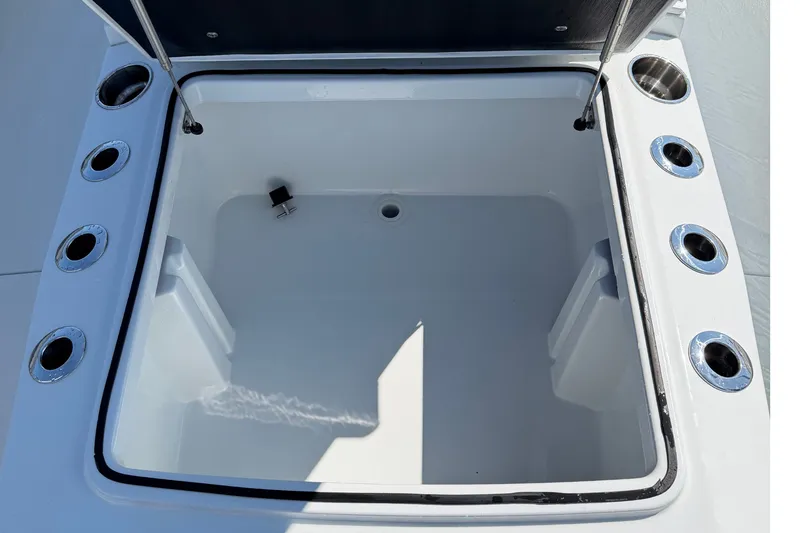 Slide: The Image of 2024 Costa Custom Boats 264HC storage compartment with multiple cup holders and secure lid. - 26