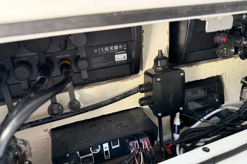 Slide: The Image of Electrical components inside a 2024 Costa Custom Boats 264HC, featuring Garmin and Simrad systems. - 24