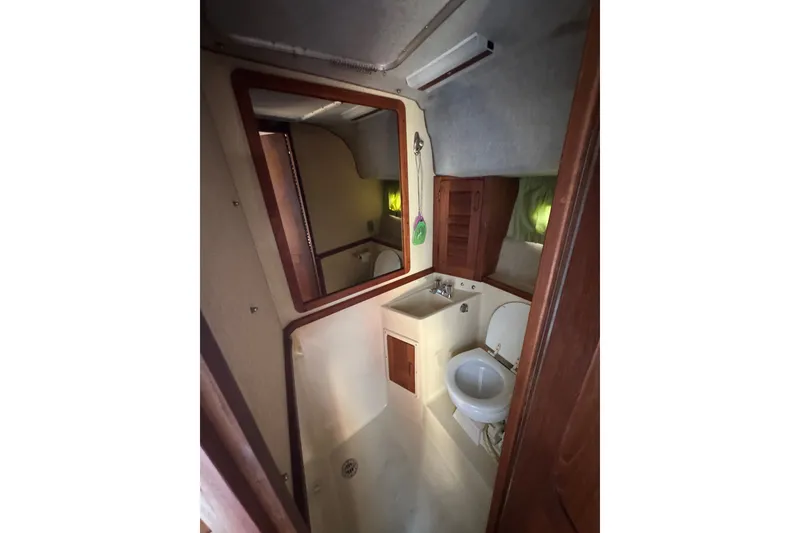 Slide: The Image of Interior of 1986 Tiara Yachts 3100 Open, featuring compact bathroom with sink and toilet. - 15