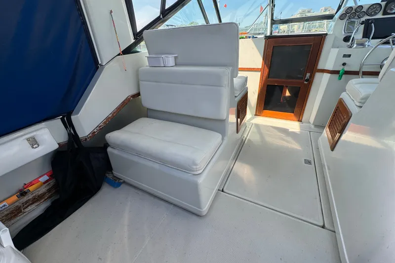 Slide: The Image of 1986 Tiara Yachts 3100 Open interior with white seating and wooden accents. - 4
