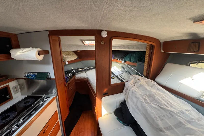Slide: The Image of Interior of a 1986 Tiara Yachts 3100 Open, featuring cozy cabin and kitchenette. - 11