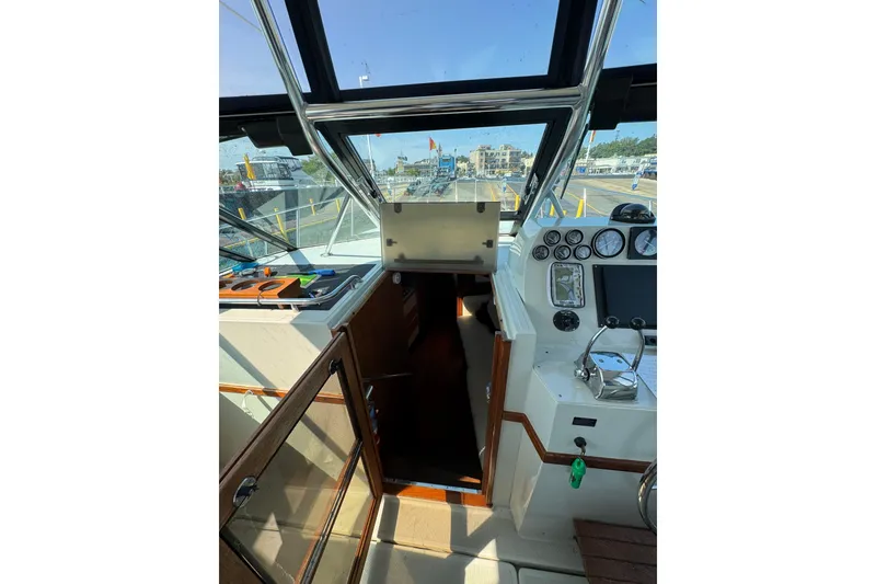 Slide: The Image of 1986 Tiara Yachts 3100 Open cockpit with steering wheel and navigation instruments. - 10