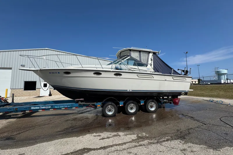 Slide: The Image of 1986 Tiara Yachts 3100 Open on trailer, parked outdoors under clear blue sky. - 19