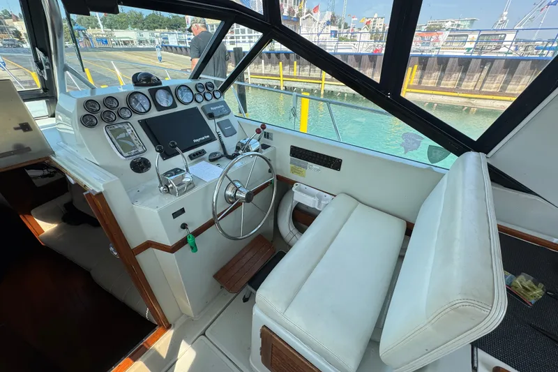 Slide: The Image of 1986 Tiara Yachts 3100 Open helm with steering wheel and navigation instruments. - 5
