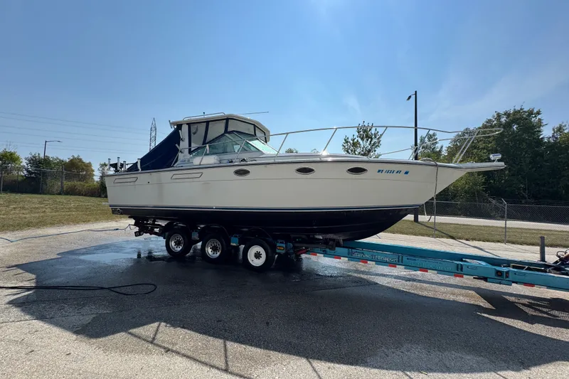 Slide: The Image of 1986 Tiara Yachts 3100 Open on trailer, ready for transport under clear skies. - 2