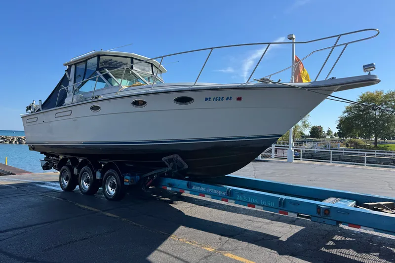 Slide: The Image of 1986 Tiara Yachts 3100 Open on trailer at marina under clear blue sky. - 17
