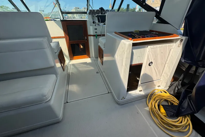 Slide: The Image of 1986 Tiara Yachts 3100 Open interior with seating, helm, and coiled yellow rope. - 6