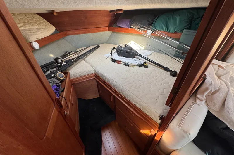 Slide: The Image of Cabin interior of 1986 Tiara Yachts 3100 Open with fishing gear on bed. - 13