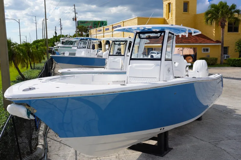 The Image of 2027 Sportsman Heritage 261 Center Console boat in blue and white, parked outdoors. - 0