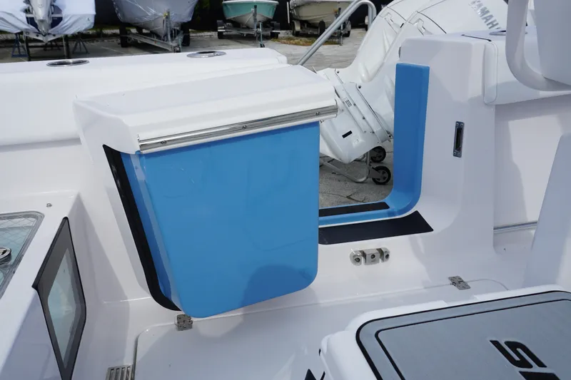 Slide: The Image of 2027 Sportsman Heritage 261 Center Console boat interior with blue storage compartment. - 12