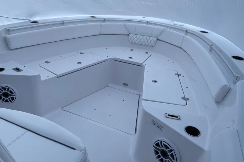 Slide: The Image of 2027 Sportsman Heritage 261 Center Console boat interior with white seating and storage compartments. - 7