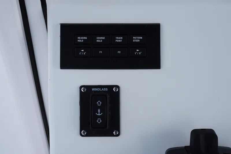 Slide: The Image of Control panel of 2027 Sportsman Heritage 261 Center Console boat with navigation and windlass buttons. - 16
