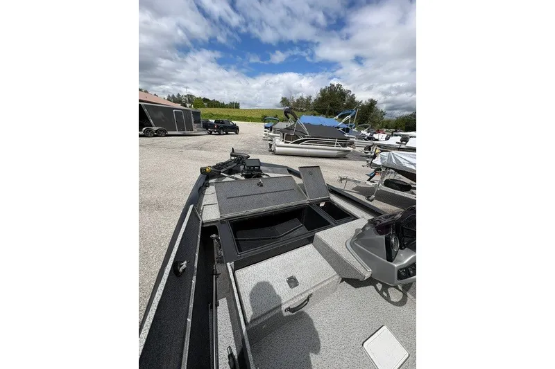 Slide: The Image of 2020 G3 Sportsman 1710 boat with open storage compartments, parked outdoors under cloudy skies. - 6