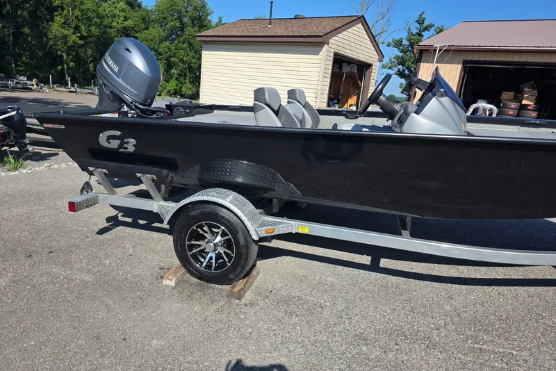 Slide: The Image of 2020 G3 Sportsman 1710 boat on trailer, parked outdoors near garages. - 1