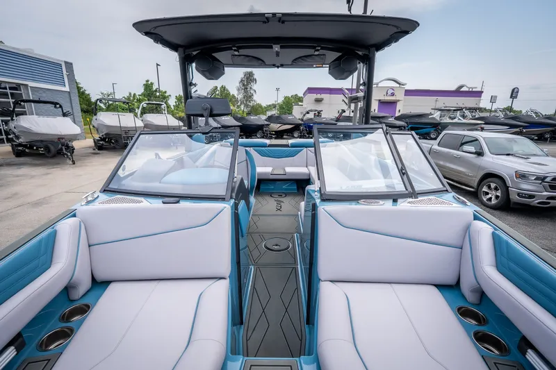 Slide: The Image of 2026 ATX Surf Boats 22 Type-S interior with blue and white seating, parked outdoors. - 21