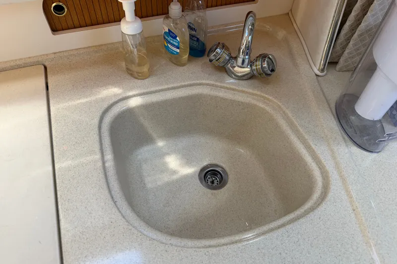 Slide: The Image of Kitchen sink area on a 1999 Sea Ray Sundancer 310 boat. - 28