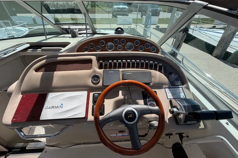 Slide: The Image of 1999 Sea Ray Sundancer 310 helm with Garmin navigation, wooden steering wheel, and control panel. - 17