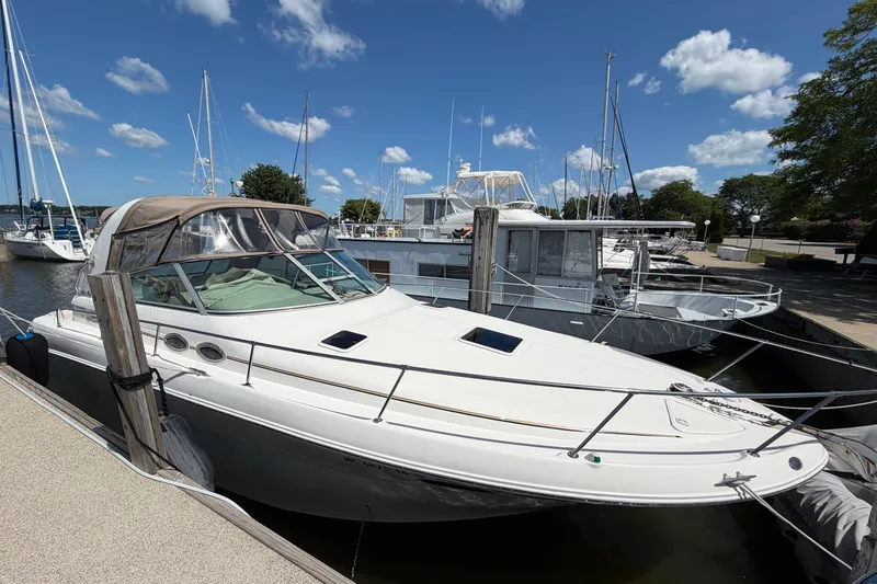 The Image of 1999 Sea Ray Sundancer 310 docked at marina under blue sky. - 0