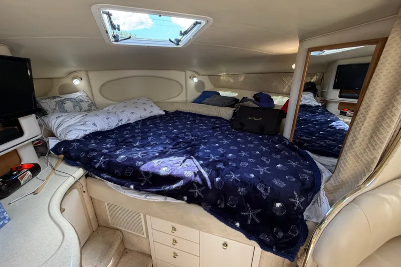 Slide: The Image of Cozy cabin interior of 1999 Sea Ray Sundancer 310 with bed and storage. - 21